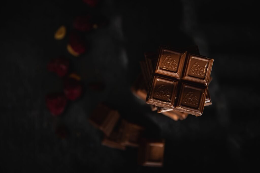 A delectable stack of gourmet chocolate bars with a dark, moody backdrop.