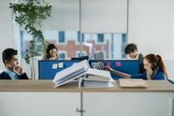 Contemporary office setting with diverse employees working diligently at their cubicles.